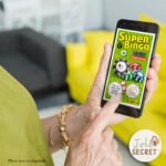 Une personne gratte un ticket interactif sur son smartphone pour annoncer une grossesse avec le message personnalisé : Tu vas être une super mamie