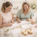 Jeux baby shower à imprimer disposés sur une table, avec des invitées en arrière-plan flouté lors d’une baby shower conviviale.