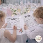 Jeux enfant mariage à imprimer, enfants occupant leur place à table avec un set d’activités mariage personnalisé pendant la réception.